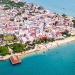Aerial view of Stone Town Zanzibar showing historic buildings and the Indian Ocean coastline.