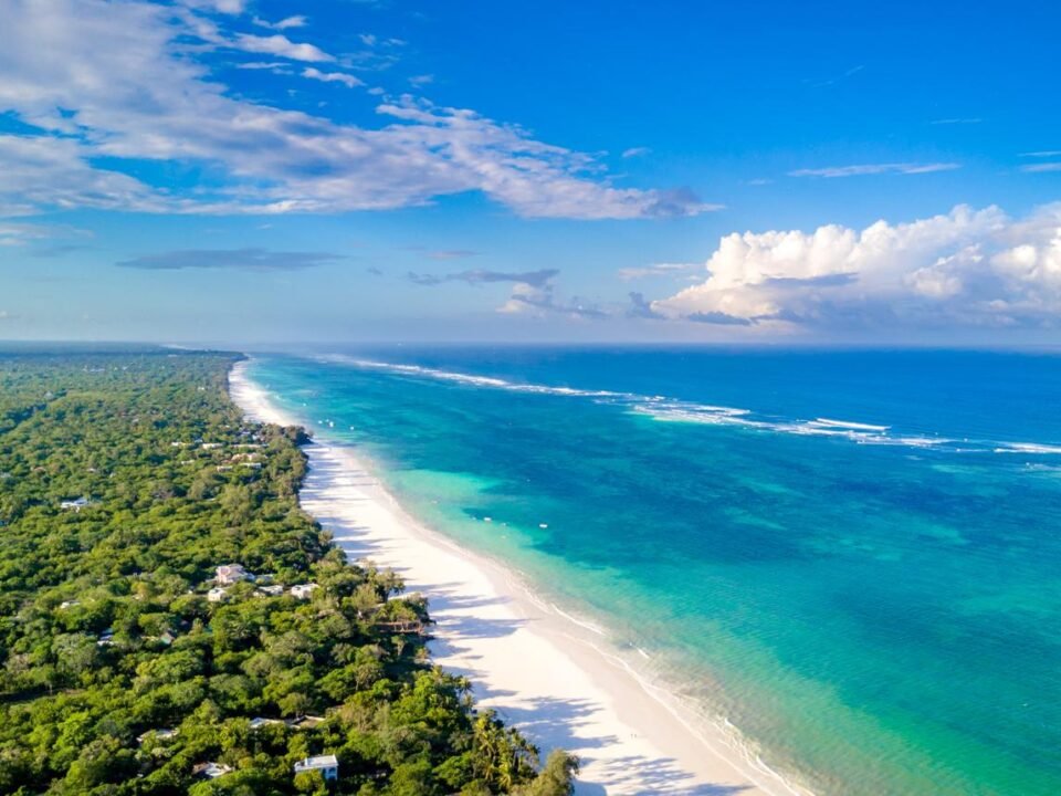 Aerial view of Diani Beach in Kenya with white sand, turquoise Indian Ocean waters, and tropical coastal forests.