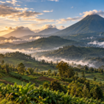 Misty volcanic peaks above green foothills in a Rwanda-inspired landscape at sunrise.