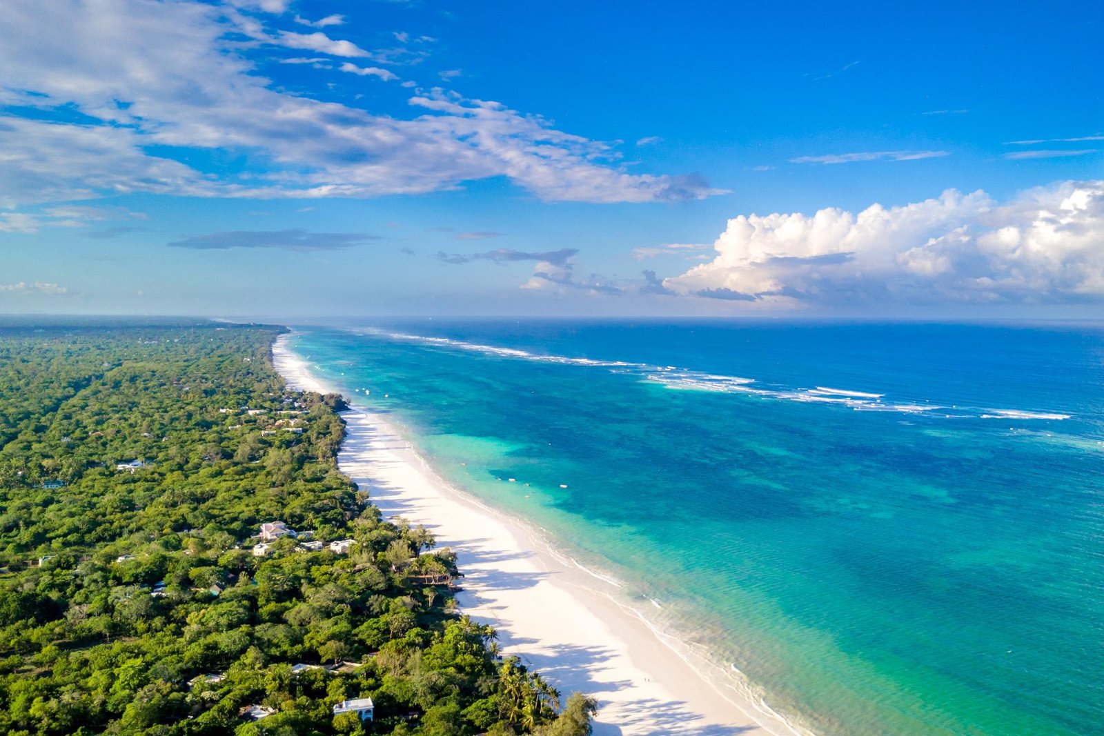 White sandy coastline and turquoise Indian Ocean waters at Diani Beach in Kenya.