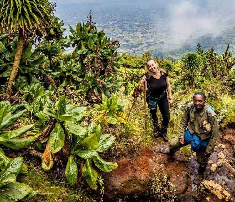 Hikers climbing the muddy Mount Bisoke trail in Rwanda.