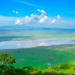 Panoramic view of Ngorongoro Crater in Tanzania, surrounded by green volcanic highlands.
