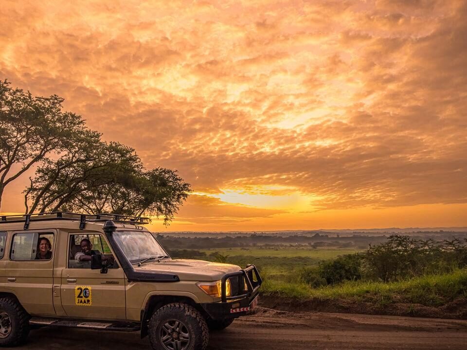 Uganda Safari Quotes comparison showing a private safari vehicle overlooking Uganda's scenic wildlife landscapes.