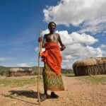 Maasai people wearing traditional clothing during a cultural village visit in Kenya.
